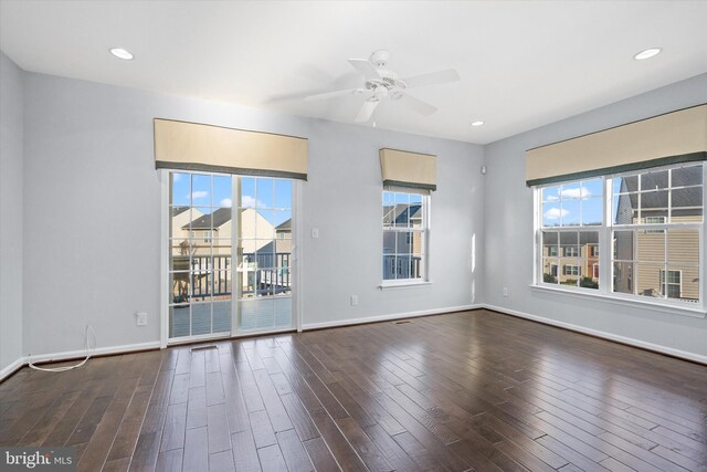 spare room with plenty of natural light, baseboards, wood finished floors, and ceiling fan
