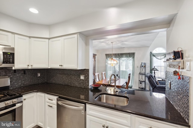 kitchen featuring a sink, white cabinets, appliances with stainless steel finishes, dark stone counters, and tasteful backsplash