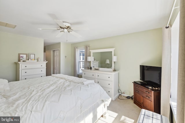 bedroom featuring a closet, visible vents, a ceiling fan, and light colored carpet