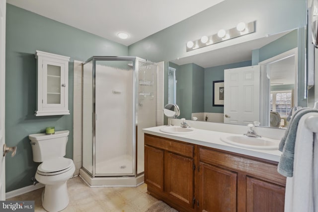 full bath featuring double vanity, a sink, and a shower stall