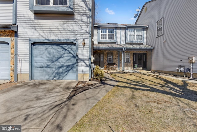 townhome / multi-family property featuring stone siding, a porch, an attached garage, and driveway