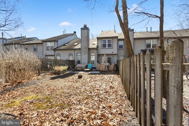 back of house featuring a chimney and fence private yard