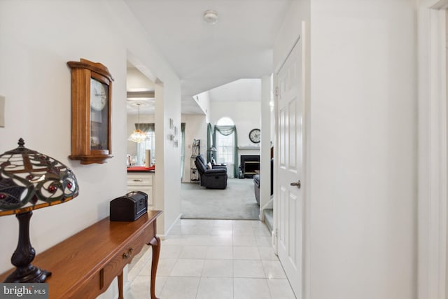 corridor featuring light carpet and light tile patterned flooring