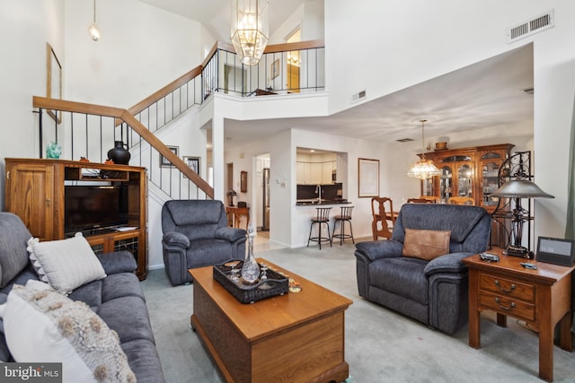 living room featuring stairs, carpet, visible vents, and a notable chandelier