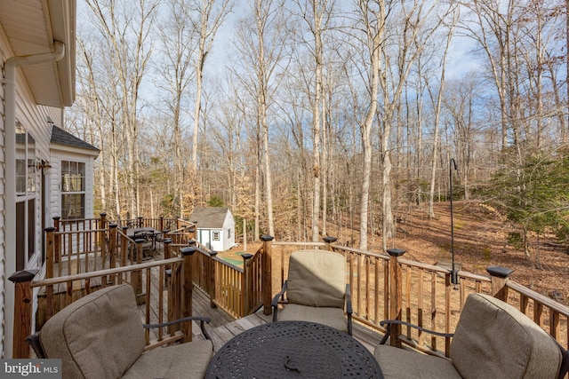 wooden terrace featuring outdoor dining area and an outdoor structure