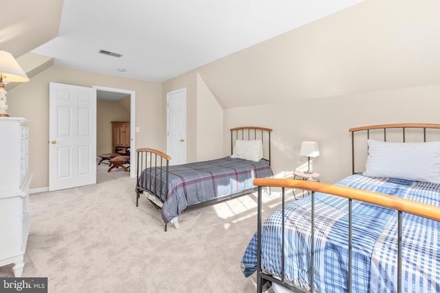 bedroom with carpet flooring, visible vents, and vaulted ceiling