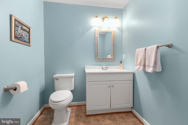 bathroom featuring vanity, toilet, and baseboards