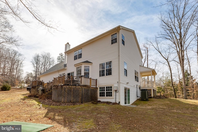 back of property with a wooden deck, central air condition unit, and a chimney