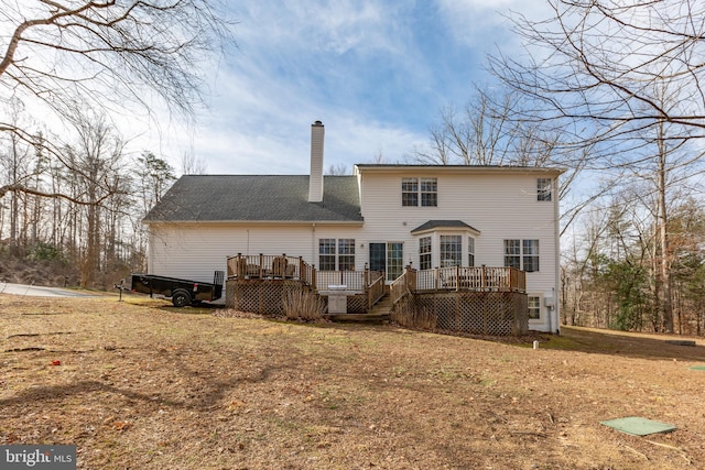 back of property featuring a wooden deck and a chimney