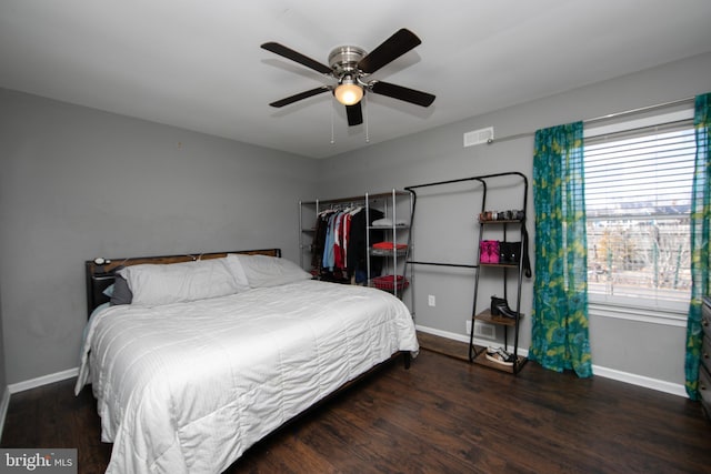 bedroom with ceiling fan, visible vents, baseboards, and wood finished floors