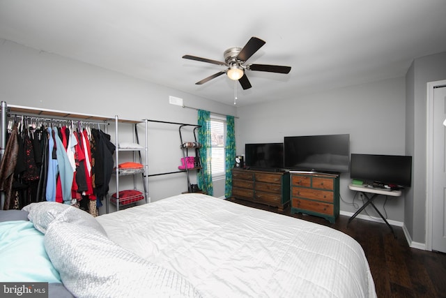 bedroom featuring a closet, ceiling fan, baseboards, and wood finished floors