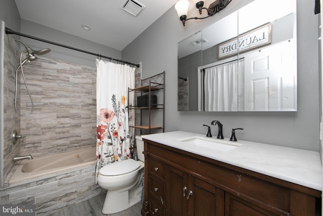 full bath with visible vents, tiled shower / bath combo, vanity, and toilet