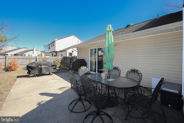 view of patio / terrace featuring outdoor dining space, a fenced backyard, a residential view, and area for grilling