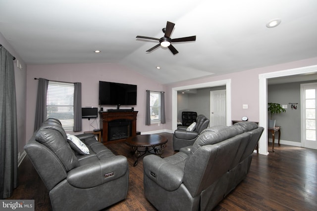 living area with lofted ceiling, a healthy amount of sunlight, a fireplace, and dark wood finished floors