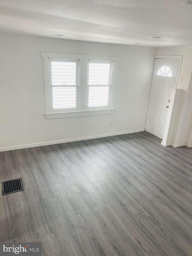 foyer entrance with visible vents, baseboards, and wood finished floors