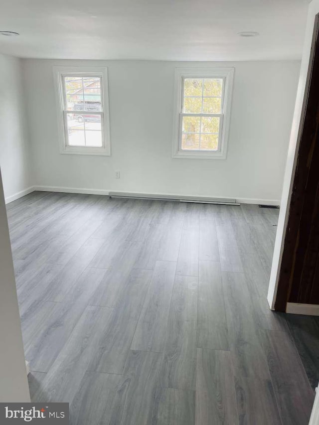 empty room featuring dark wood finished floors and baseboards