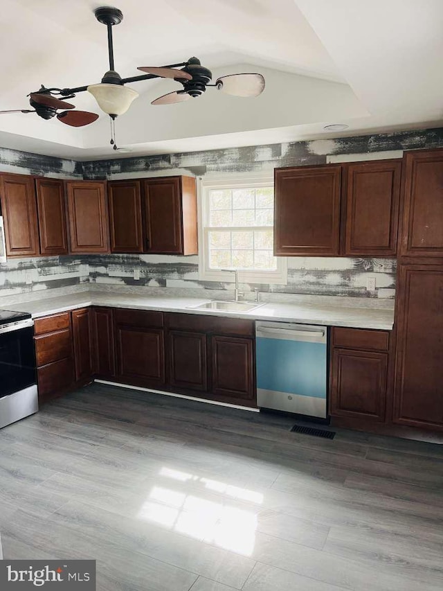 kitchen featuring range with electric stovetop, light countertops, decorative backsplash, stainless steel dishwasher, and a sink