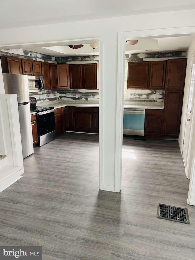 kitchen featuring stainless steel appliances, light countertops, visible vents, and decorative backsplash