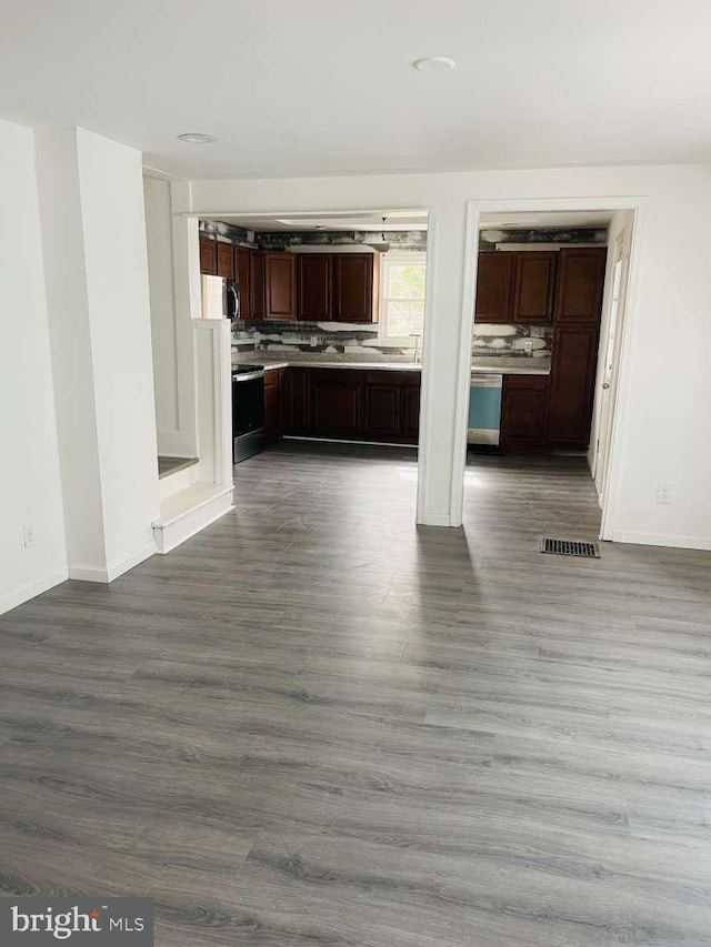 interior space featuring visible vents, dark wood-type flooring, light countertops, stainless steel range with electric stovetop, and backsplash