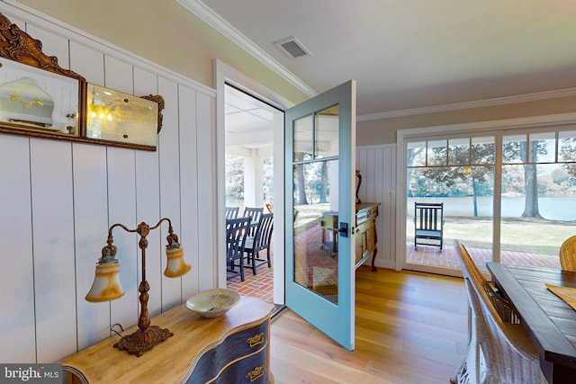 entryway with french doors, light wood finished floors, visible vents, and crown molding