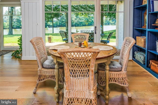 dining area with a water view and wood finished floors