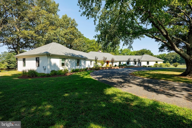 ranch-style house featuring brick siding, driveway, and a front lawn