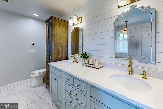 full bathroom featuring marble finish floor, double vanity, a sink, and toilet