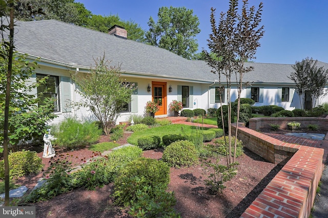 single story home with a shingled roof and a chimney