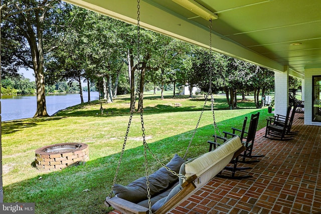 view of patio / terrace featuring an outdoor fire pit and a water view