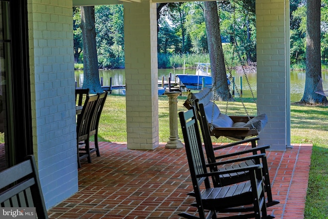 view of patio with a water view, a boat dock, and boat lift