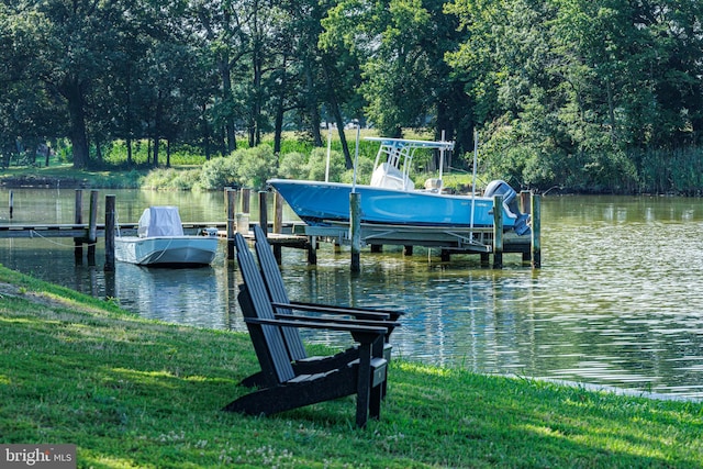 view of dock with a water view, a yard, and boat lift