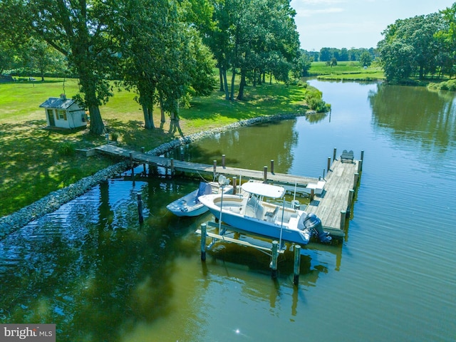 view of dock with a yard, a water view, and boat lift