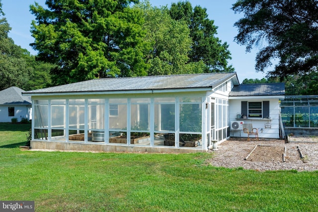 back of house featuring a yard and a sunroom