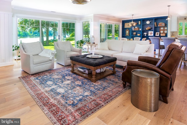 living area featuring light wood-type flooring and crown molding