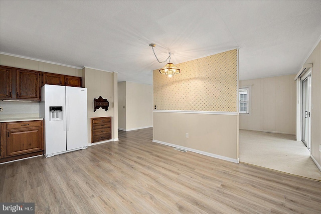 kitchen with open floor plan, visible vents, white refrigerator with ice dispenser, and light wood-style floors