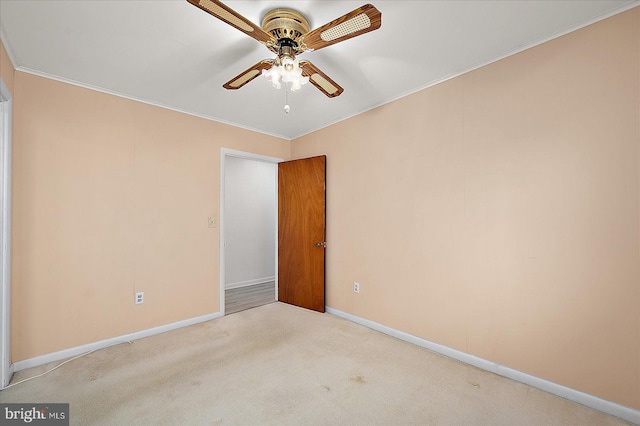 spare room with carpet flooring, ceiling fan, crown molding, and baseboards