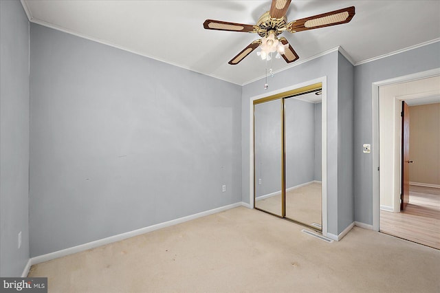 unfurnished bedroom featuring a closet, baseboards, ornamental molding, and carpet flooring