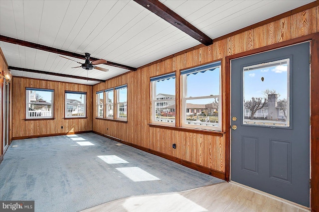 unfurnished sunroom with beam ceiling and a ceiling fan