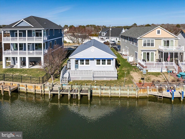 rear view of house featuring a yard, a water view, and a fenced backyard