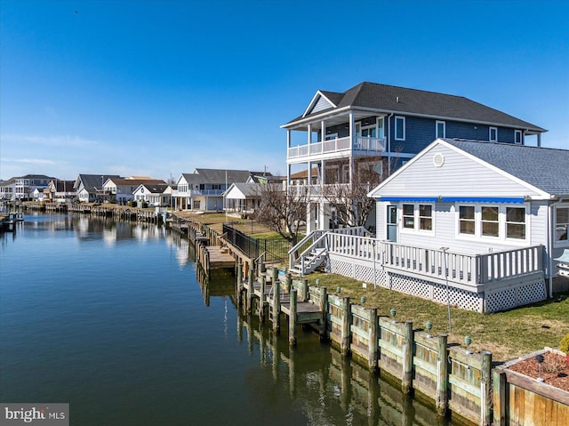 dock area featuring a residential view, a deck with water view, and a yard