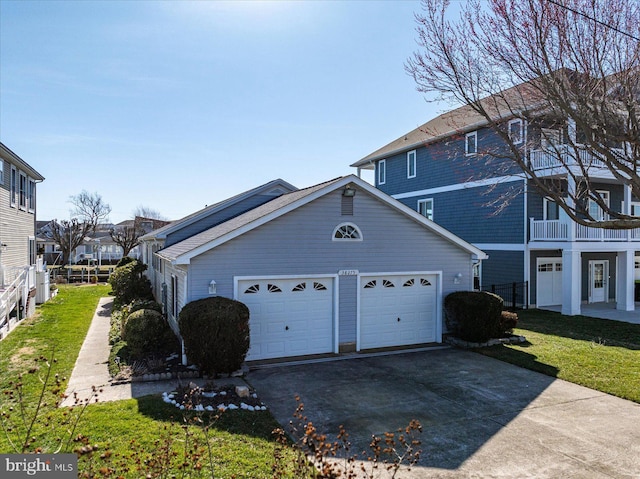 view of side of home with a lawn, a garage, and driveway