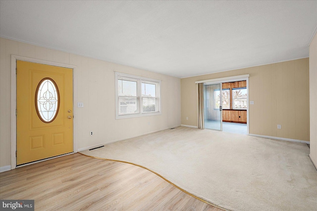 entrance foyer featuring visible vents, baseboards, and wood finished floors