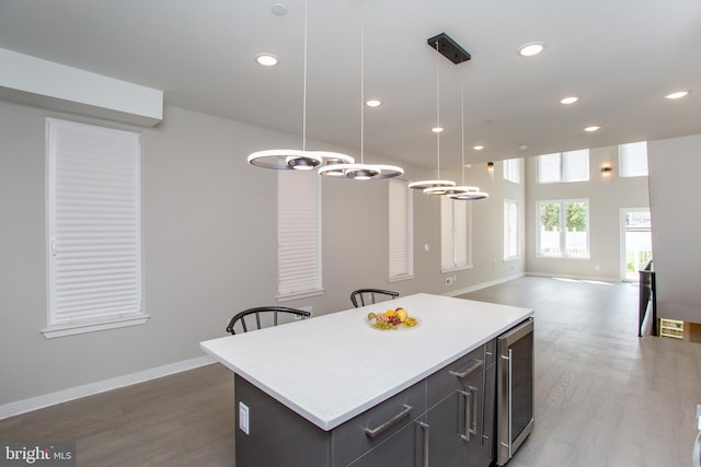 kitchen with light countertops, wood finished floors, and a center island