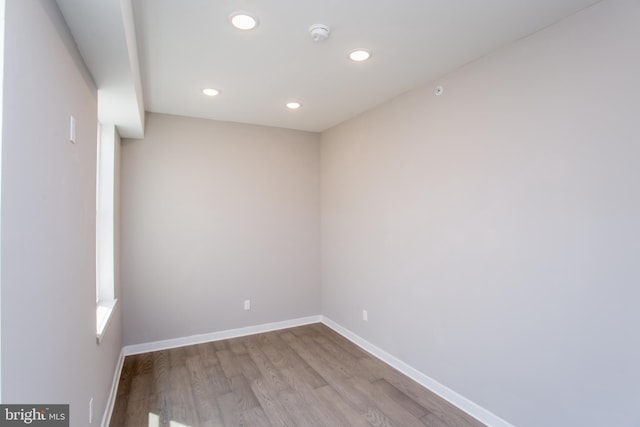 spare room featuring baseboards, wood finished floors, and recessed lighting