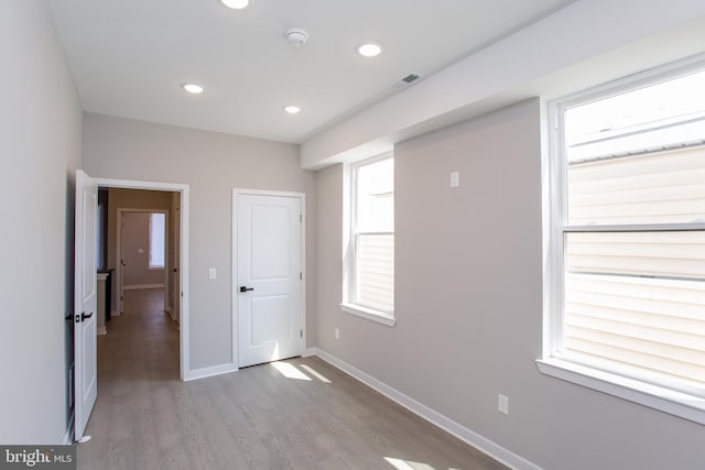 unfurnished bedroom with recessed lighting, visible vents, baseboards, and wood finished floors