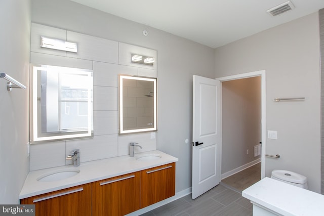 full bath featuring double vanity, visible vents, backsplash, and a sink