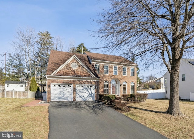 view of front of house featuring driveway, brick siding, an attached garage, fence, and a front yard