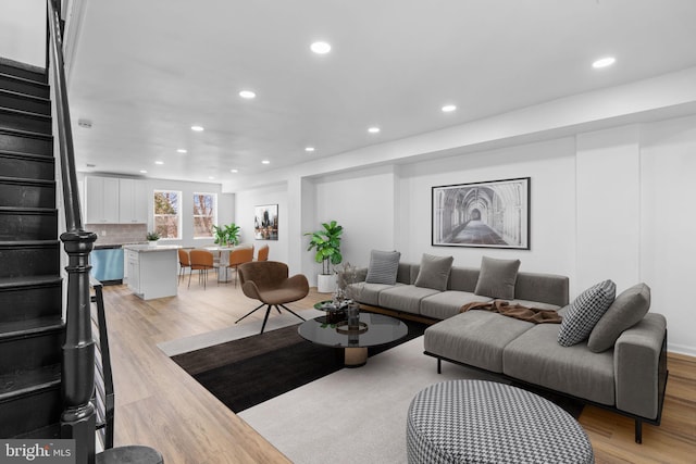 living area featuring stairs, recessed lighting, and light wood-style floors