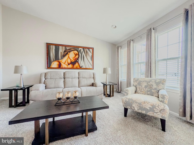 living area featuring lofted ceiling, baseboards, and carpet flooring