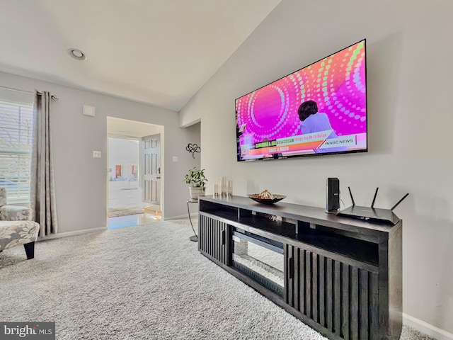 living area with lofted ceiling, carpet, and baseboards